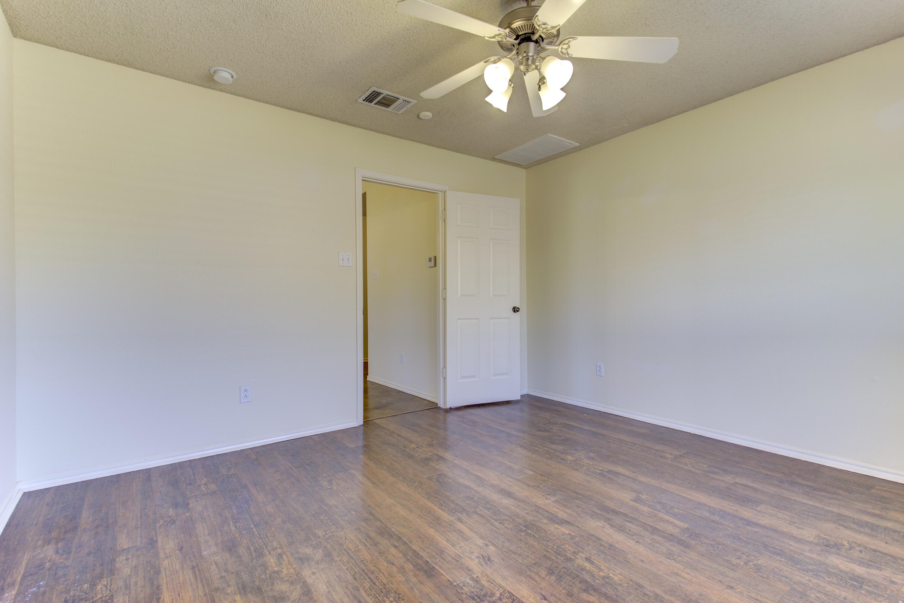 6804 7th Street Lubbock, TX 79416 - Photo 15 of 42 a view of an empty room with wooden floor