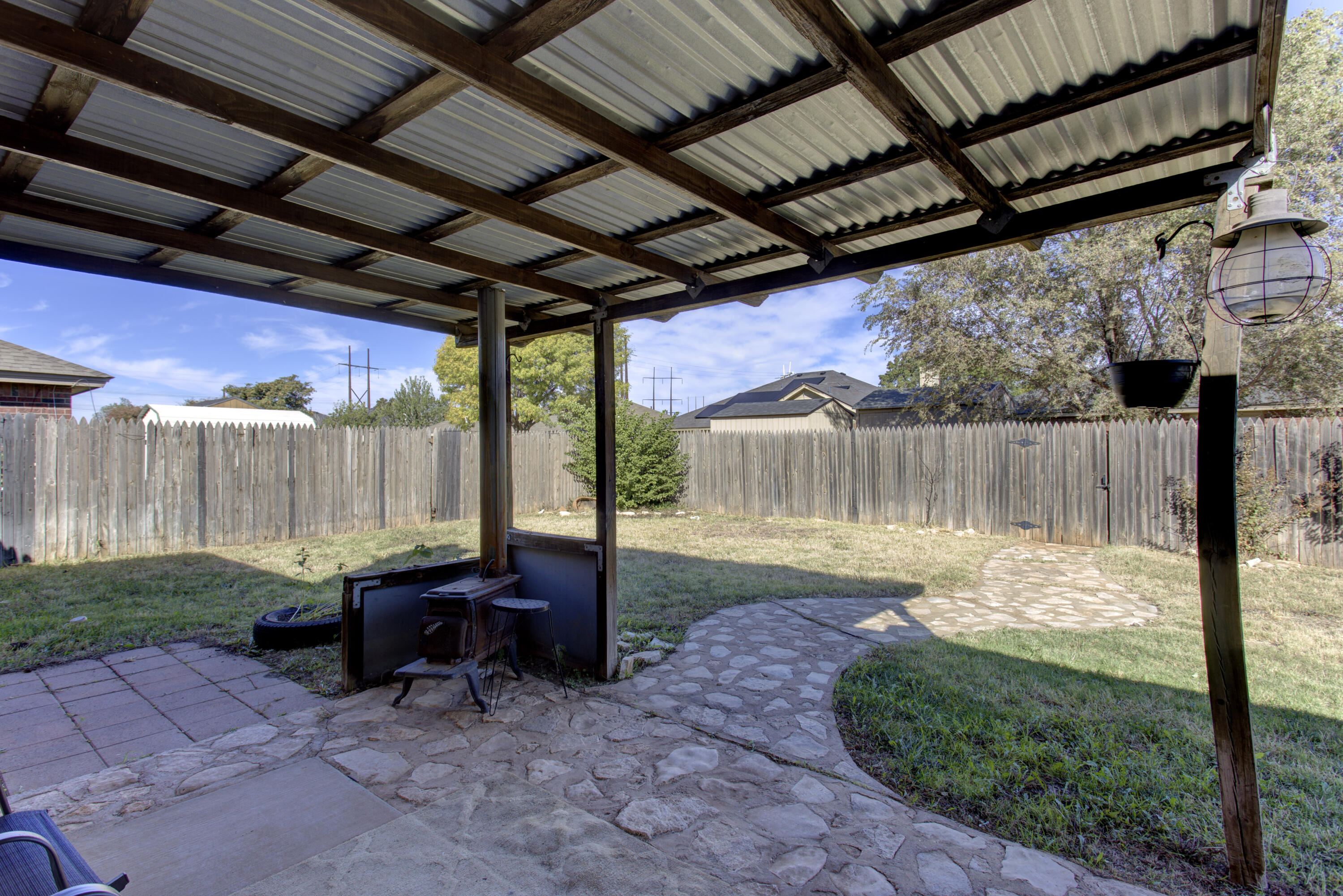 6804 7th Street Lubbock, TX 79416 - Photo 40 of 42 a view of a backyard with table and chairs a barbeque with wooden fence