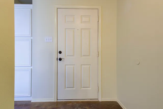 an empty room with a window and a chandelier