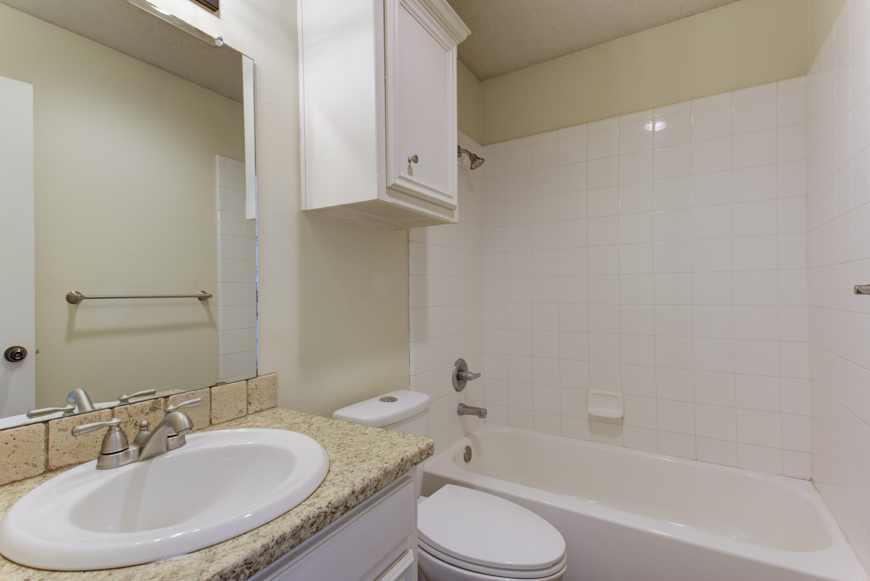 6804 7th Street Lubbock, TX 79416 - Photo 6 of 42 a bathroom with a granite countertop sink toilet and shower