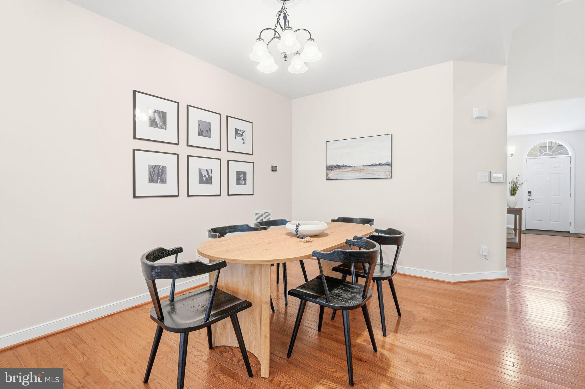 13141 Triple Crown Loop Gainesville, VA 20155 - Photo 17 of 68 a view of a dining room with furniture and wooden floor