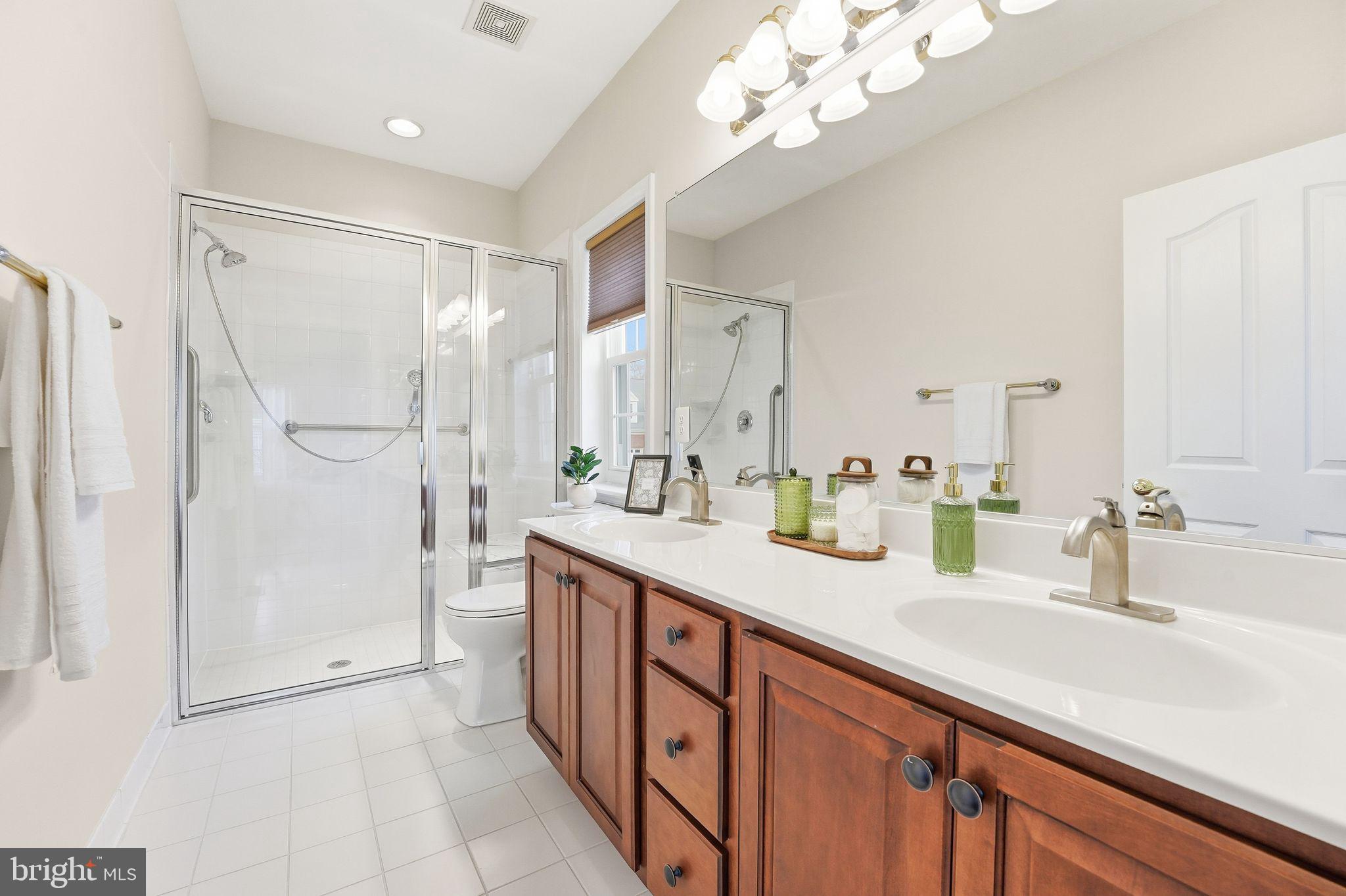13141 Triple Crown Loop Gainesville, VA 20155 - Photo 37 of 68 a bathroom with a shower sink and mirror