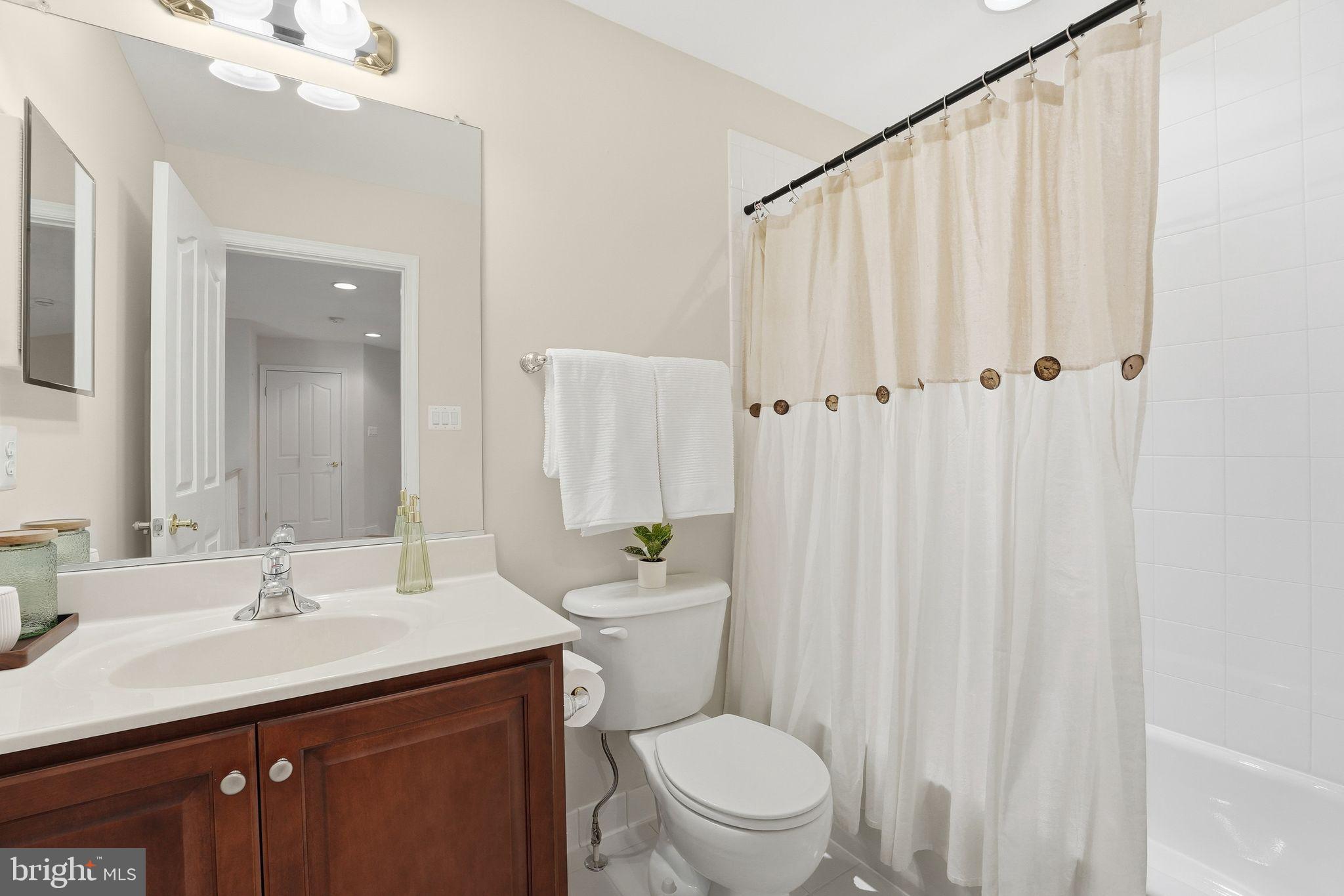 13141 Triple Crown Loop Gainesville, VA 20155 - Photo 41 of 68 a bathroom with a sink a toilet and shower curtain
