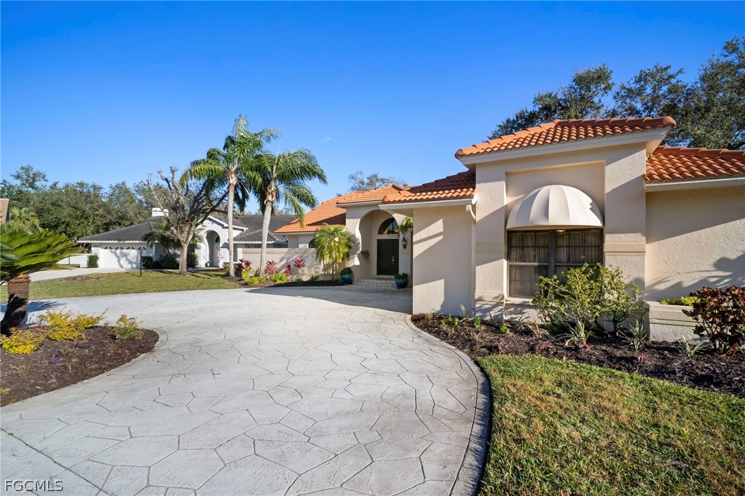 11772 Mahogany Run Fort Myers, FL 33913 - Photo 3 of 50 a front view of a house with a garden