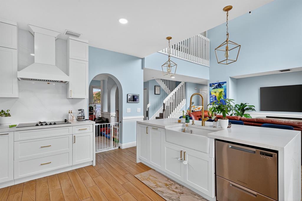 18676 Southwest 16th Street Pembroke Pines, FL 33029 - Photo 18 of 61 a kitchen with a sink dishwasher a stove and white cabinets with wooden floor