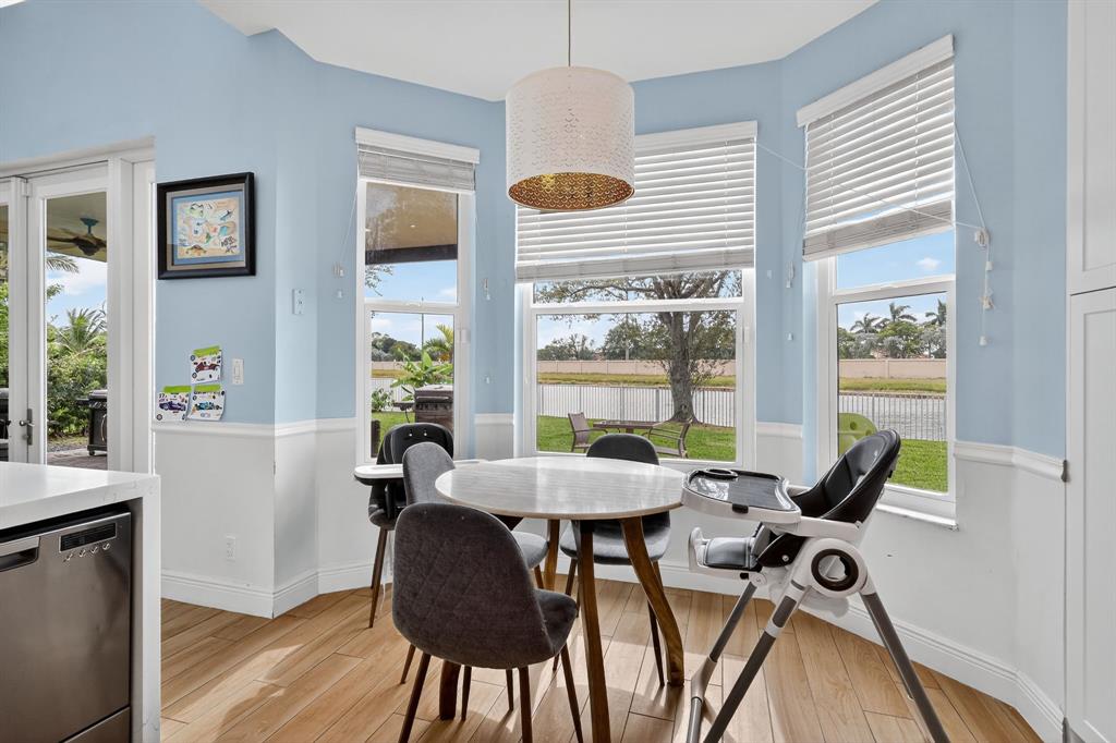 18676 Southwest 16th Street Pembroke Pines, FL 33029 - Photo 21 of 61 a view of a dining room with furniture wooden floor and a chandelier