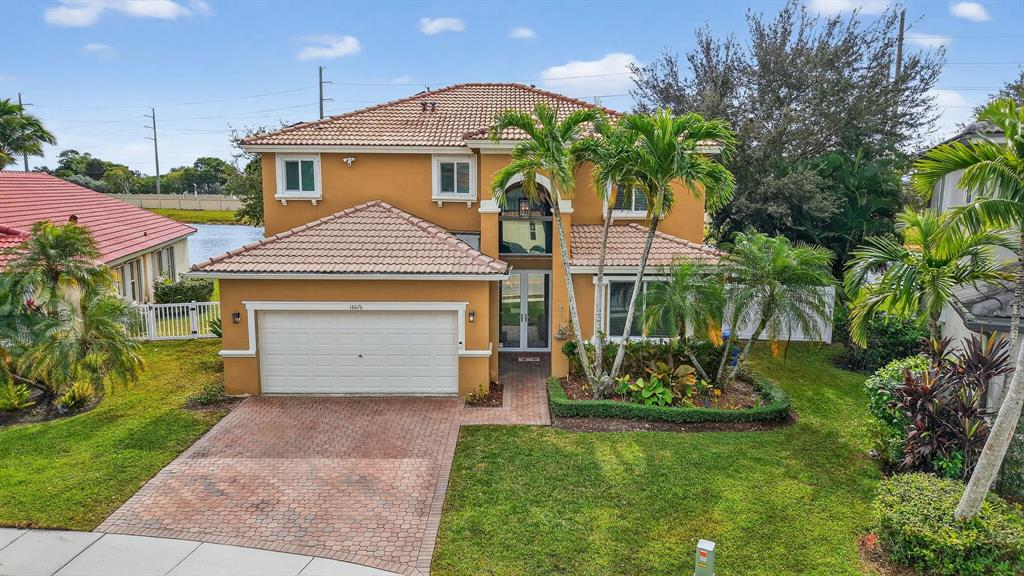 18676 Southwest 16th Street Pembroke Pines, FL 33029 - Photo 52 of 61 a front view of a house with a garden and plants