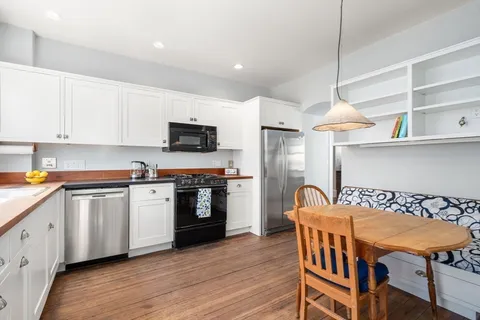 a kitchen with stainless steel appliances granite countertop a kitchen island hardwood floor sink and stove