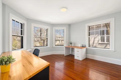 a living room with stainless steel appliances kitchen island wooden floor and large window