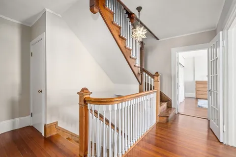 a view of a hallway with wooden floor and staircase