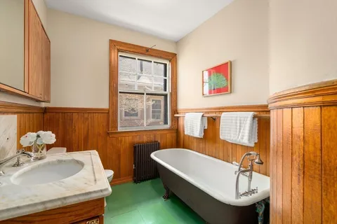 a bathroom with a tub sink and mirror