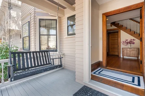 a view of a balcony with furniture and wooden floor