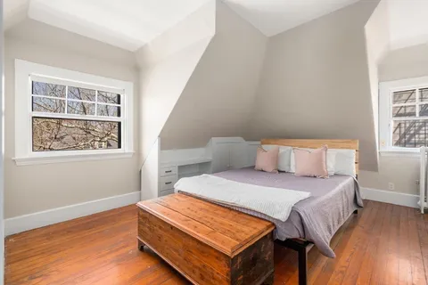 a bedroom with a bed and wooden floor