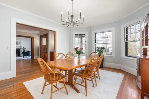a dining room with furniture a chandelier and wooden floor