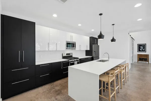 a kitchen with a stove a refrigerator and a sink