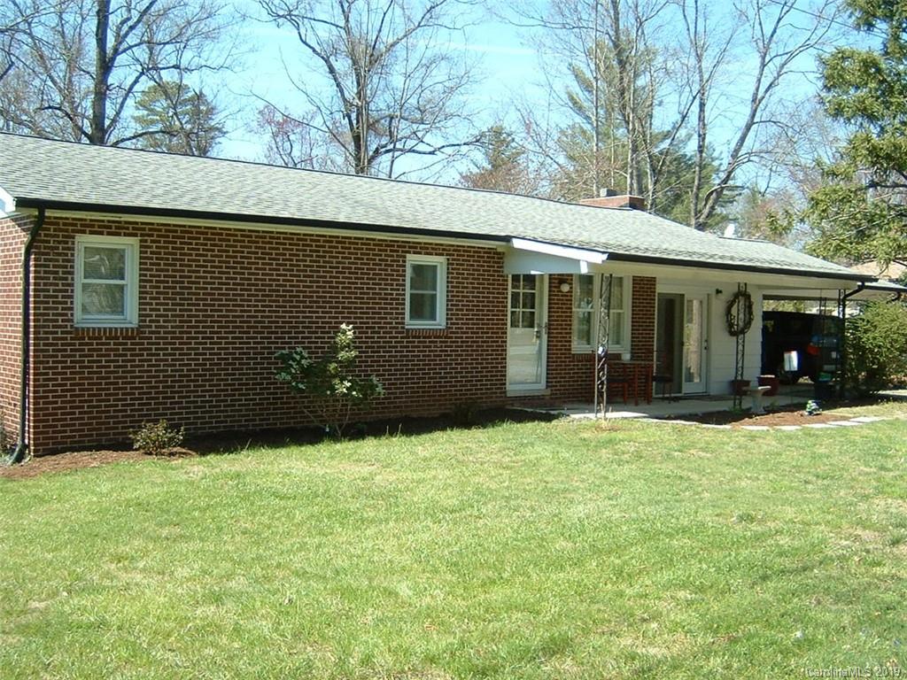 a backyard of a house with yard and outdoor seating