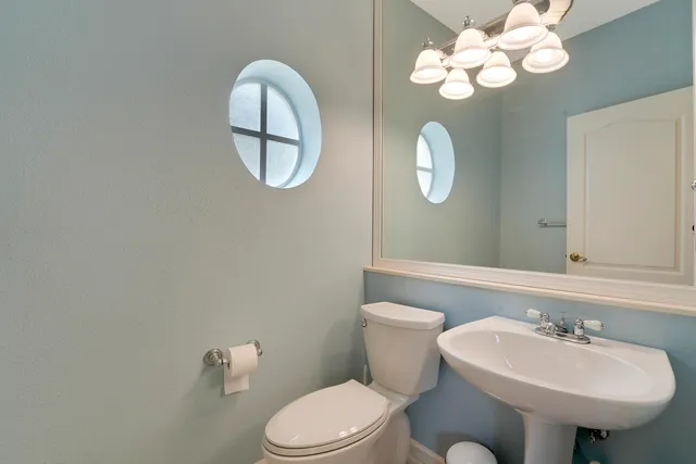 a bathroom with a toilet sink and mirror