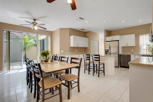 a dining room with furniture and kitchen view