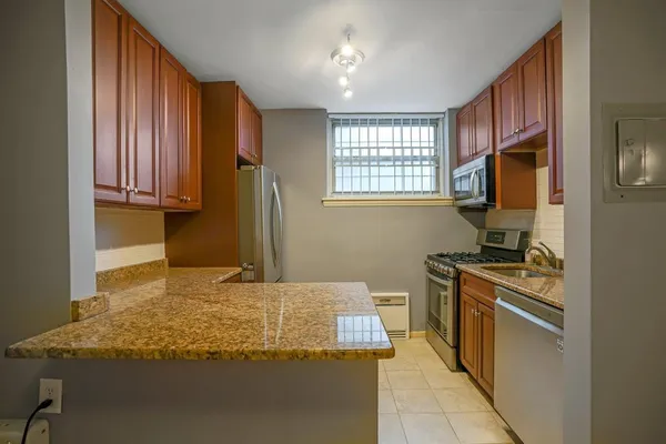 a kitchen with kitchen island granite countertop a stove sink and microwave