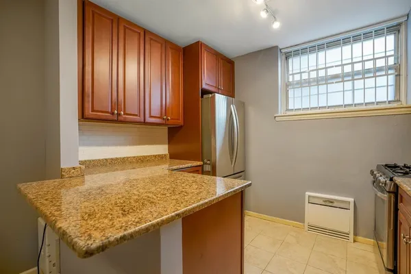 a kitchen with a granite countertop sink and refrigerator