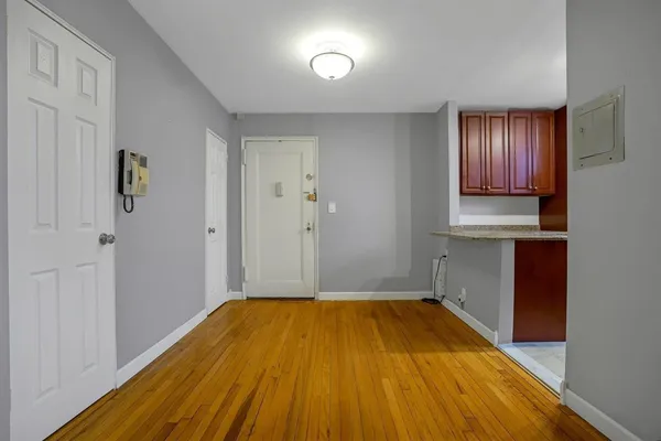 a view of a room with wooden floor and cabinet