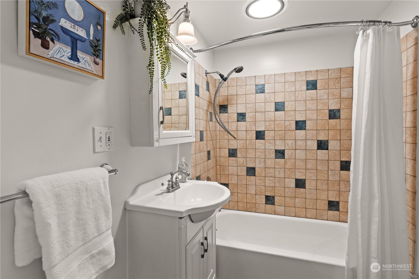 9721 Fremont Avenue North Seattle, WA 98103 - Photo 16 of 27 a bathroom with a sink a mirror a bathtub and shower