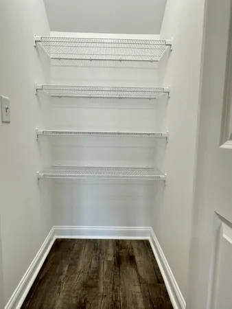 a view of a closet with wooden floor