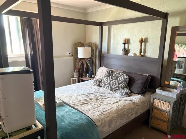 a bedroom with a bed window and mirror