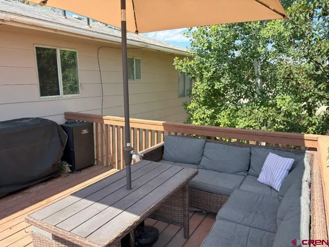 a balcony with wooden floor and outdoor seating