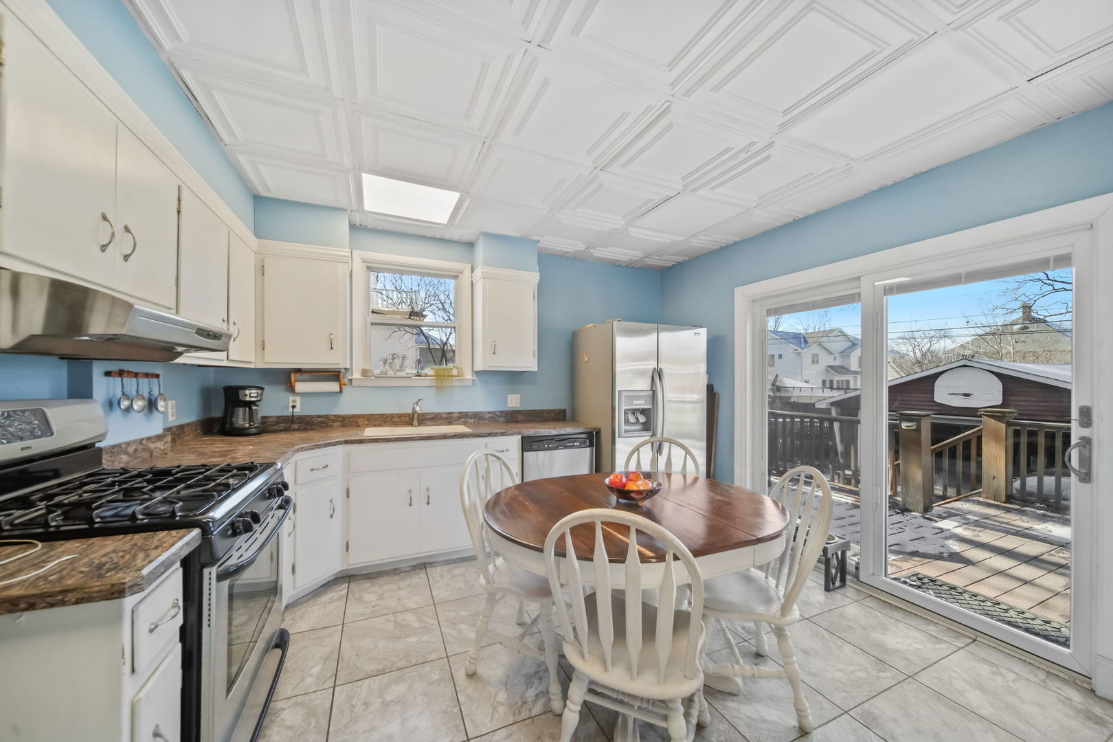 4142 Wolf Road Western Springs, IL 60558 - Photo 12 of 34 a kitchen with stainless steel appliances granite countertop a stove a sink dishwasher a dining table and chairs with wooden floor