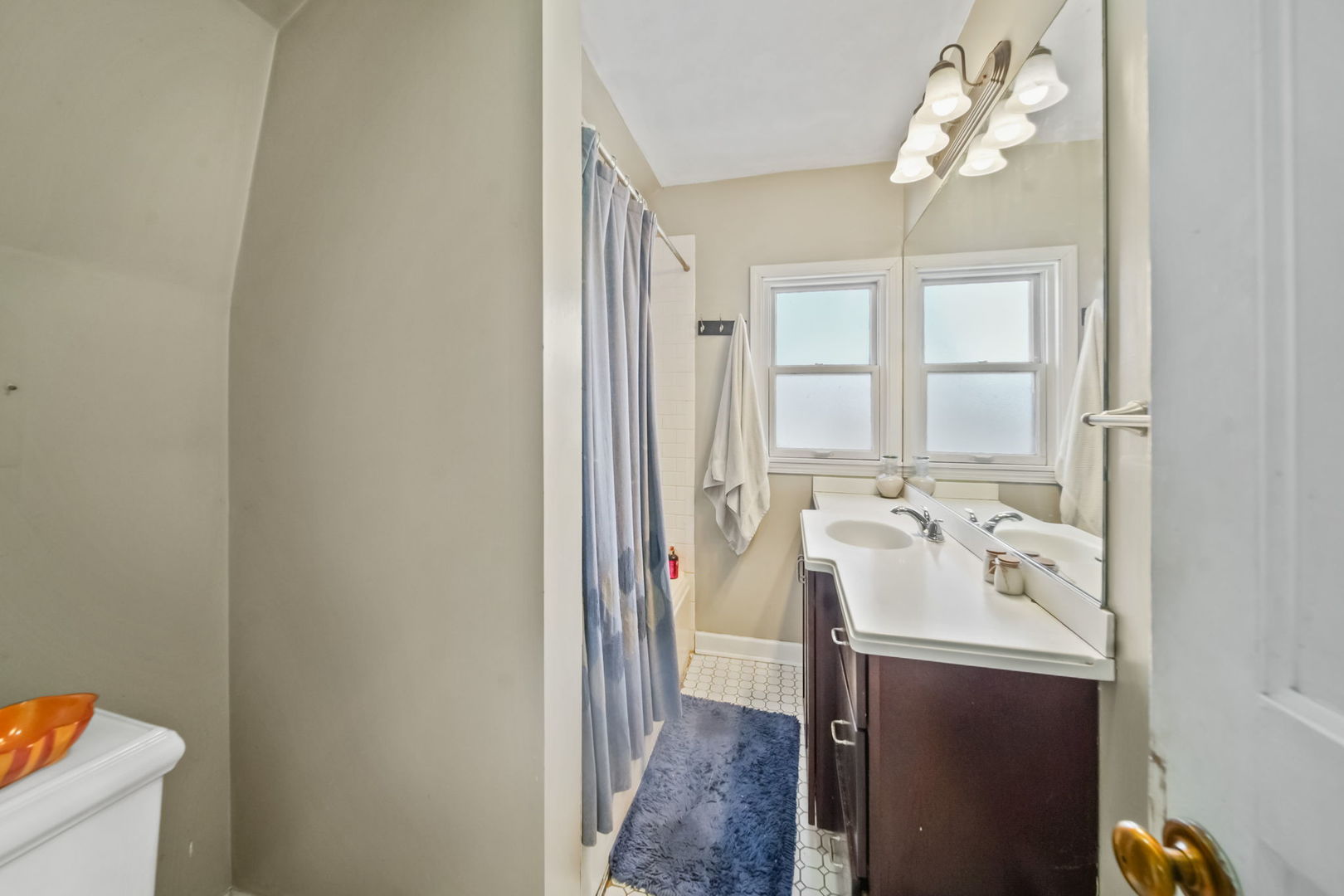 4142 Wolf Road Western Springs, IL 60558 - Photo 16 of 34 a bathroom with a sink a light fixture and a mirror