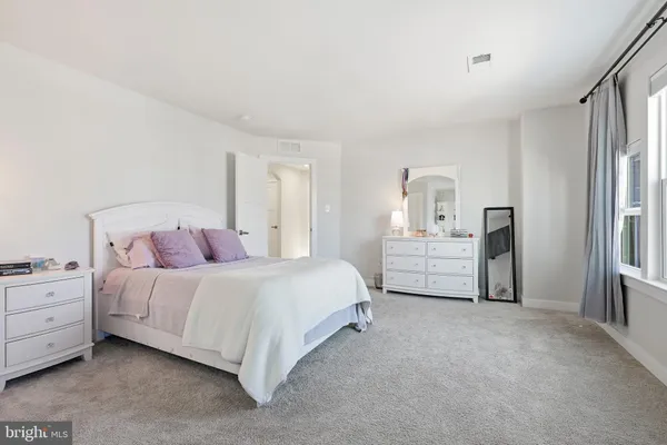 a room with a bed and a dresser