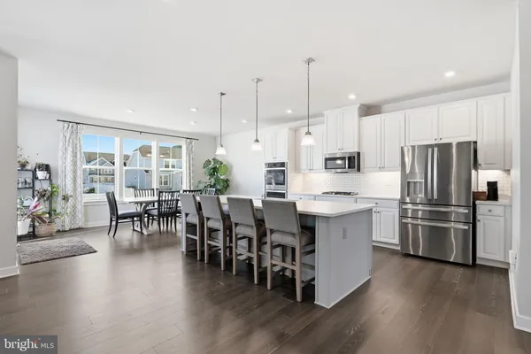 a kitchen with stainless steel appliances kitchen island wooden floors and center island