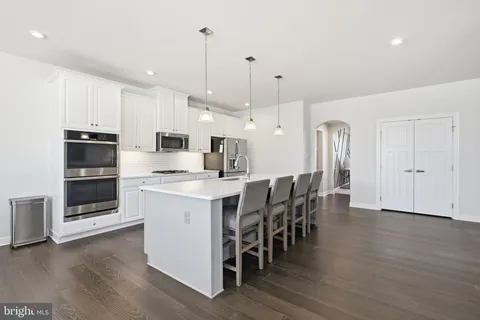 a large white kitchen with lots of counter space sink and appliances