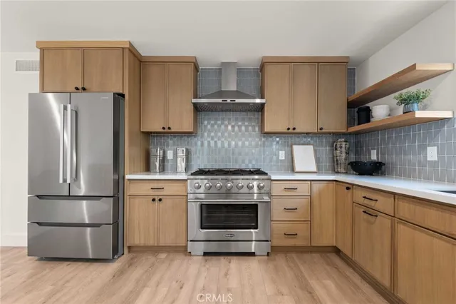 a kitchen with stainless steel appliances granite countertop a stove and white cabinets