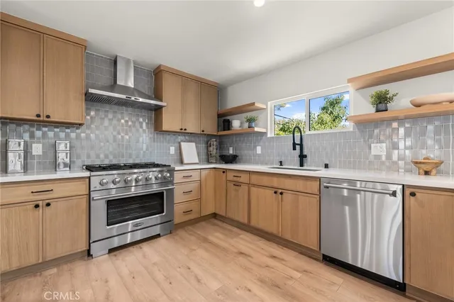 a kitchen with stainless steel appliances a stove a refrigerator and cabinets