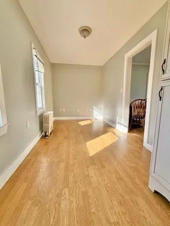 a view of a livingroom with wooden floor and furniture
