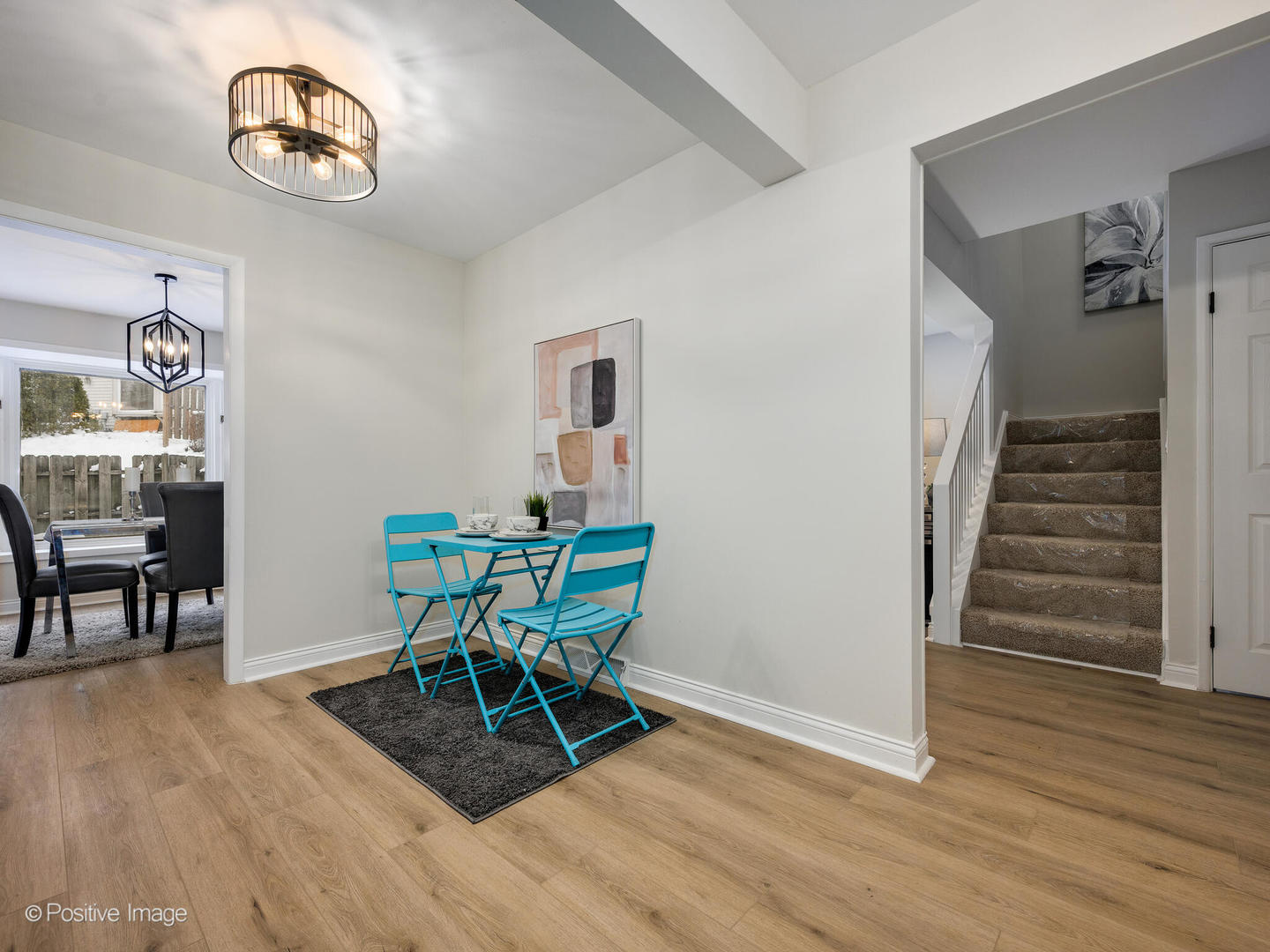 526 Thomas Road Bolingbrook, IL 60440 - Photo 10 of 23 a dining room with wooden floor a chandelier a wooden table and chairs