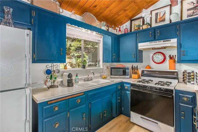 a kitchen with stainless steel appliances a stove a sink and a refrigerator