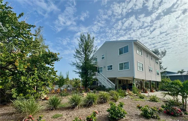 a front view of a house with plants and trees