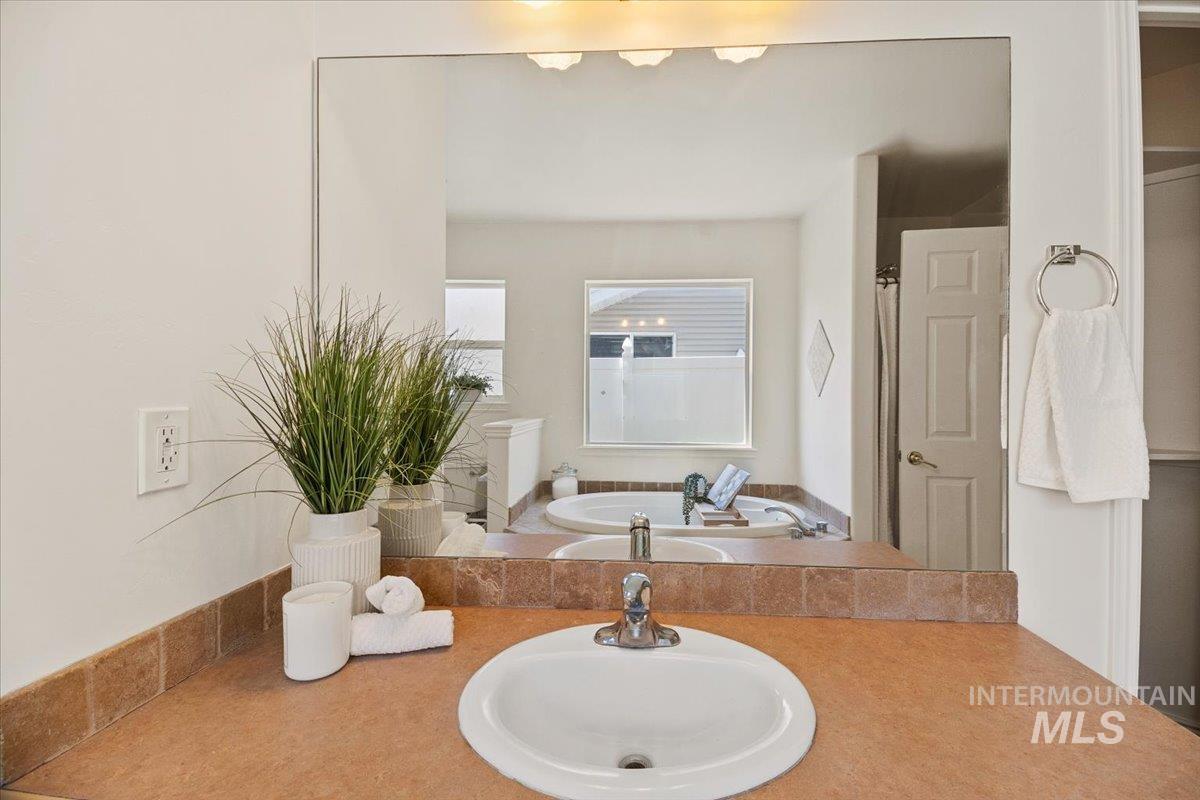 2032 Talus Loop Twin Falls, ID 83301 - Photo 34 of 43 Bathroom featuring an expansive wall-mounted mirror, dual sinks, and an integrated soaking tub