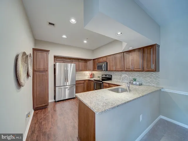 a kitchen with a sink a refrigerator and cabinets