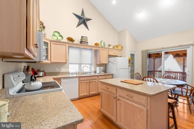 a living room with furniture a flat screen tv and kitchen view