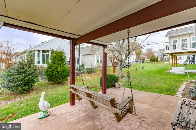 a view of a white house with a large tree and yard