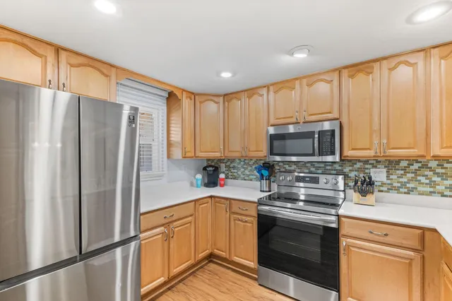 a kitchen with stainless steel appliances a refrigerator sink and microwave