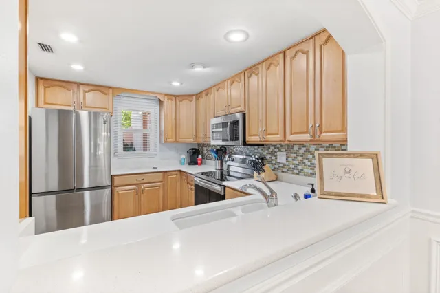 a kitchen with stainless steel appliances granite countertop a refrigerator sink and cabinets