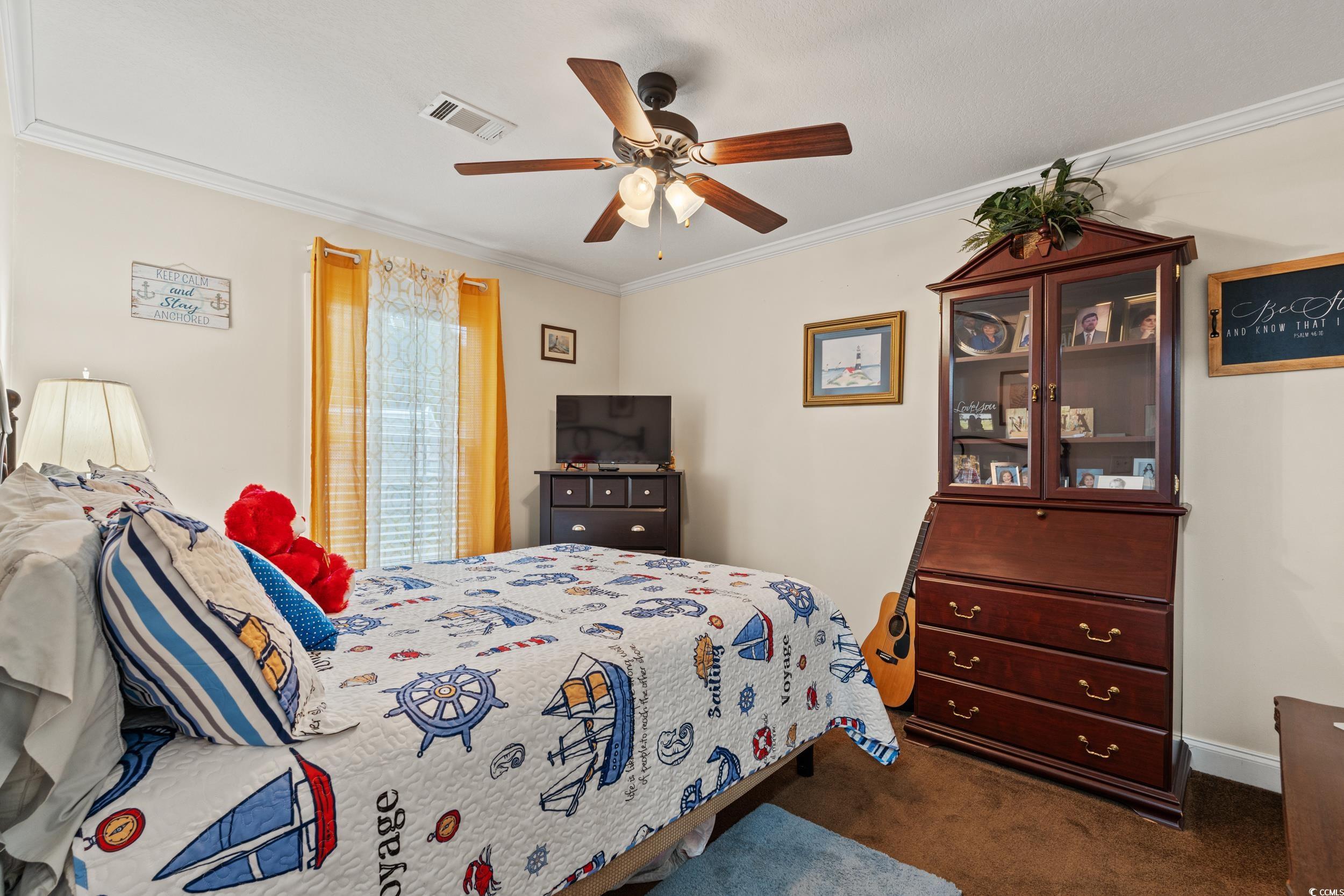 90 Offshore Drive Murrells Inlet, SC 29576 - Photo 21 of 40 Bedroom with dark colored carpet, crown molding, and a ceiling fan