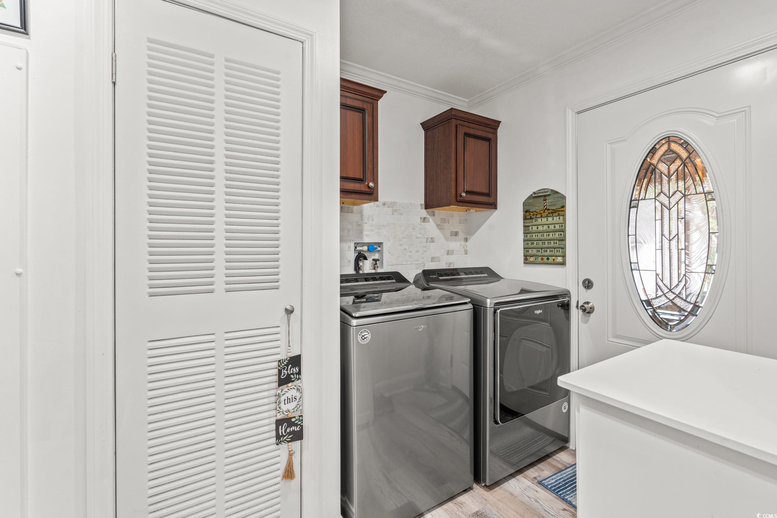 90 Offshore Drive Murrells Inlet, SC 29576 - Photo 23 of 40 Laundry area featuring light wood-style floors, cabinet space, washer and dryer, and ornamental molding