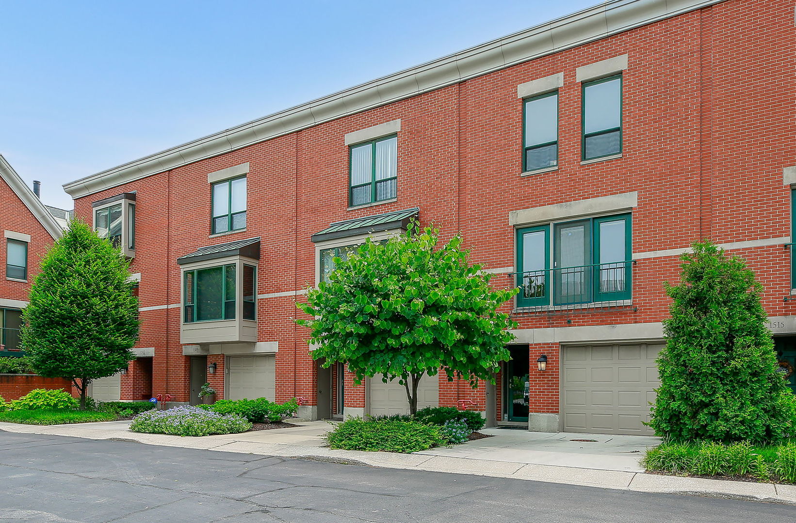 a front view of a house with garage and plants