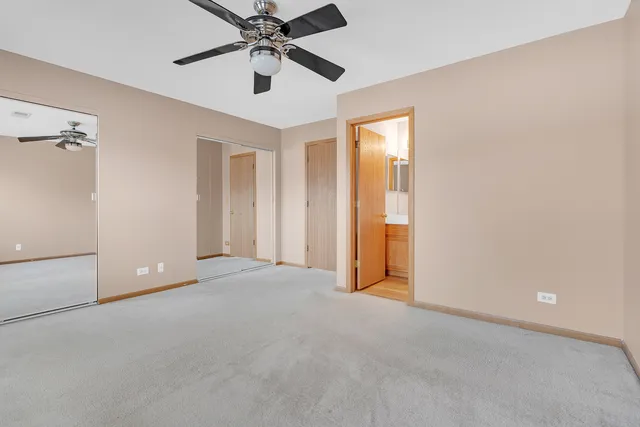 an empty room with chandelier fan